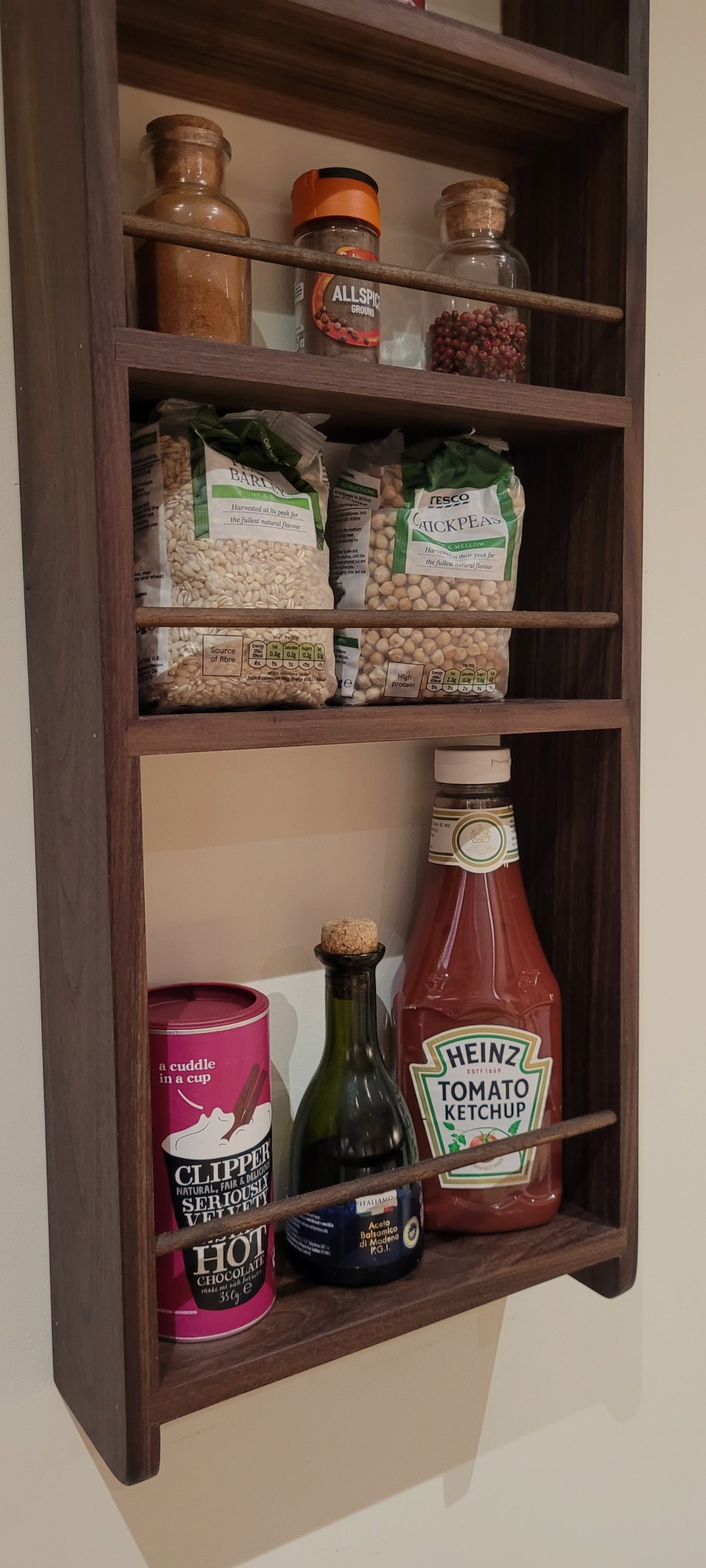 Close up of solid walnut larder rack with items arranged on the shelves